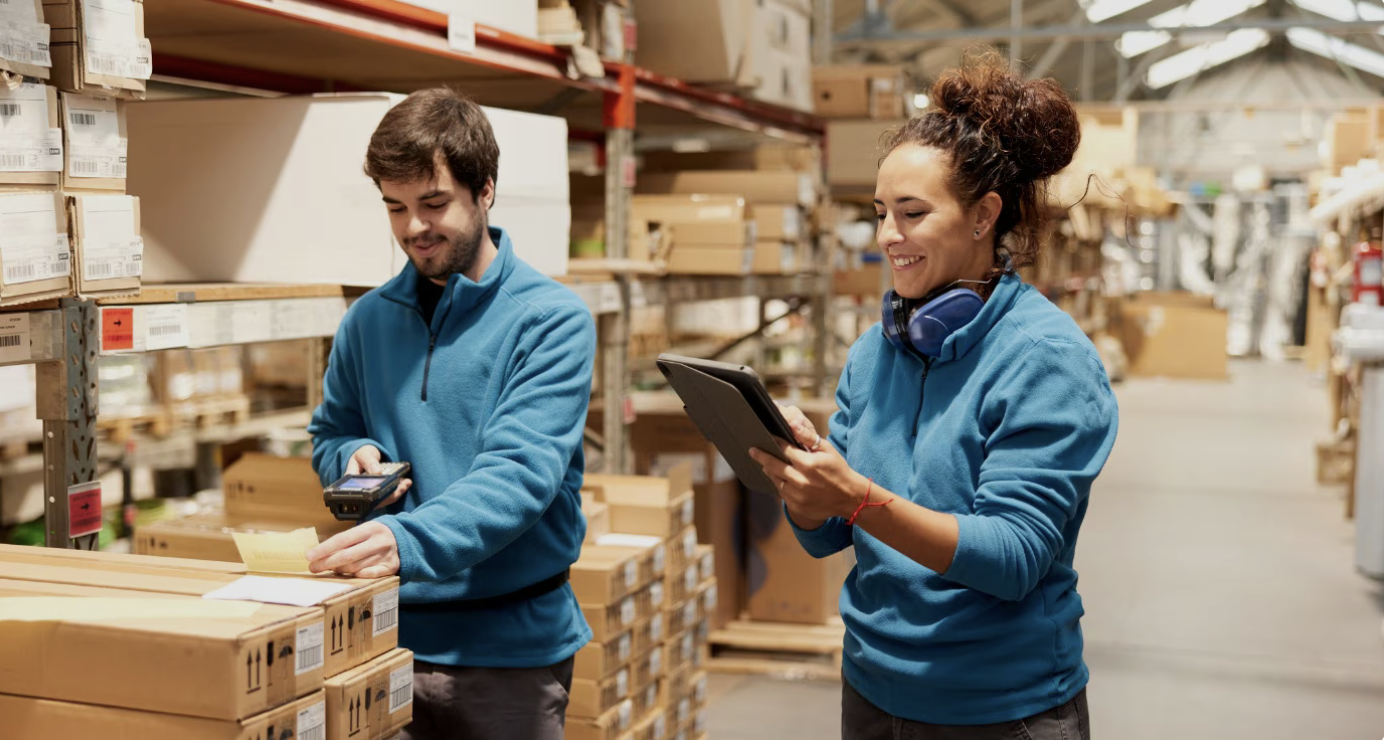 Lagerarbeiter scannt Barcode im großen Lager, Kollege notiert die Daten – Personalvermittlung Lagerarbeiter